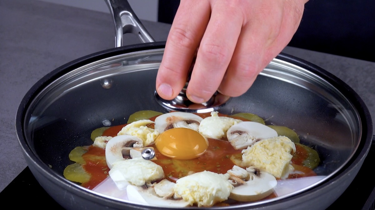 Ei wird als Spiegelei in der Mitte der Pizza mit Kartoffeln platziert und in Pfanne mit geschlossenem Deckel gegart