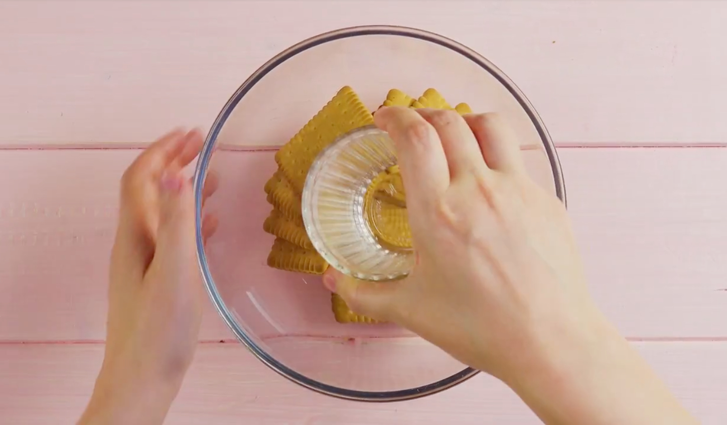 Butterkekse werden mit einem Glas in einer SchÃ¼ssel zerstampft