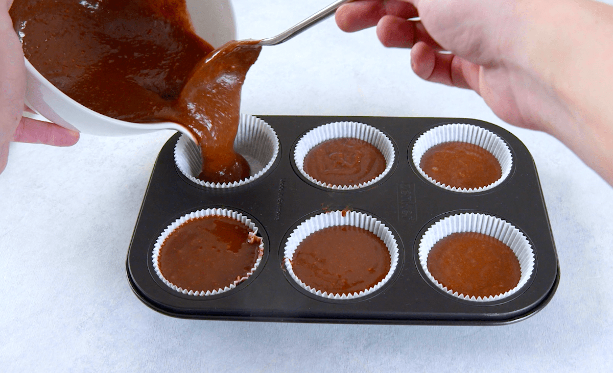 Nutella-Teig wird in eine Muffinform gegeben.