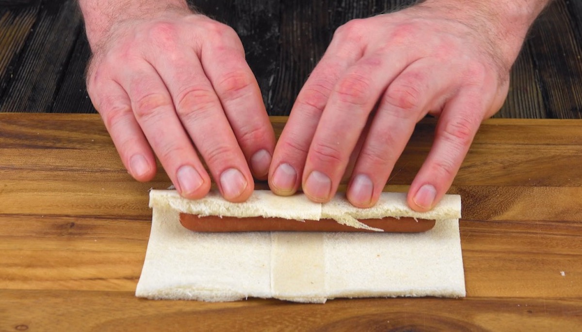 WÃ¼rstchen wird in Toastbrotscheiben eingerollt