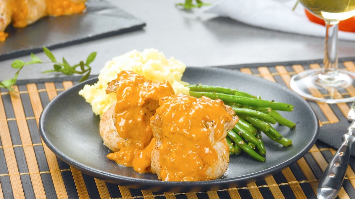 Eine Portion gefÃ¼llte Schweineschnitzel mit Kartoffelbrei, SoÃŸe und grÃ¼nen Bohnen