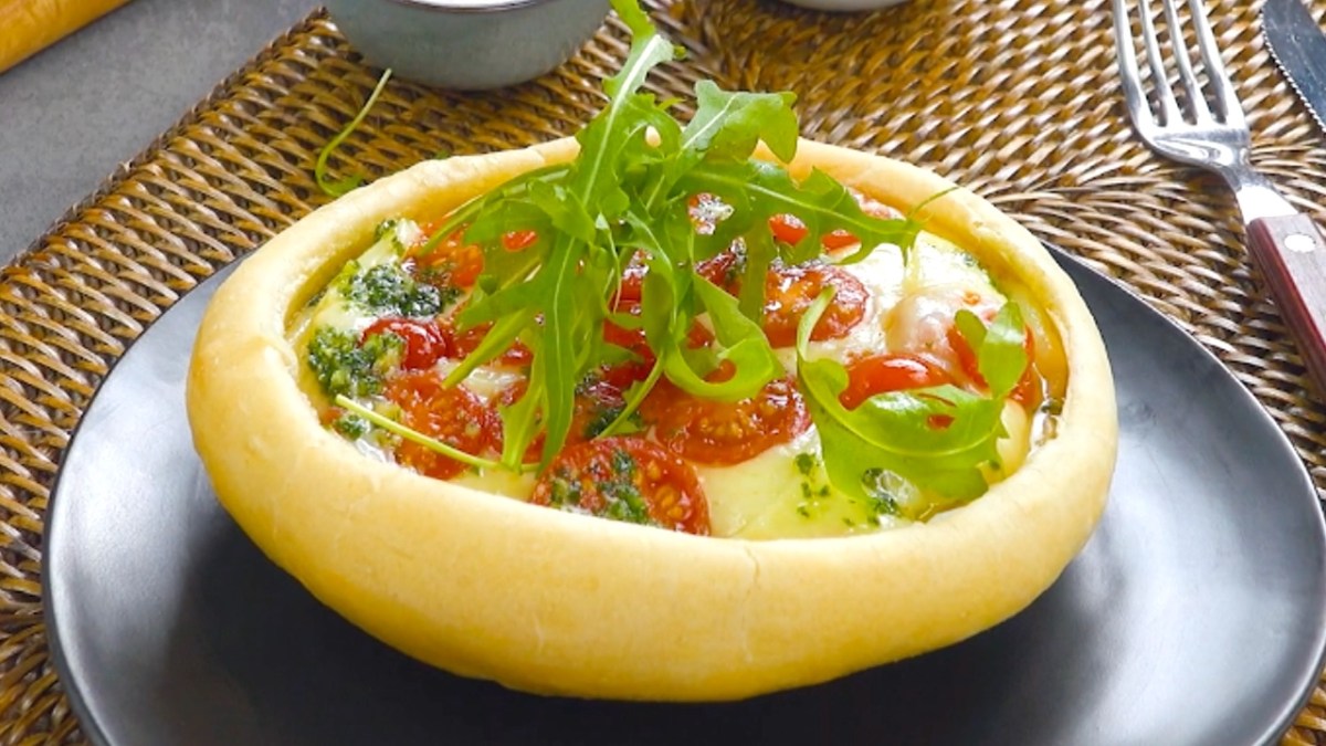 Ein Pizza Pot Pie mit Tomaten-Mozzarella-Füllung und frischem Rucola.