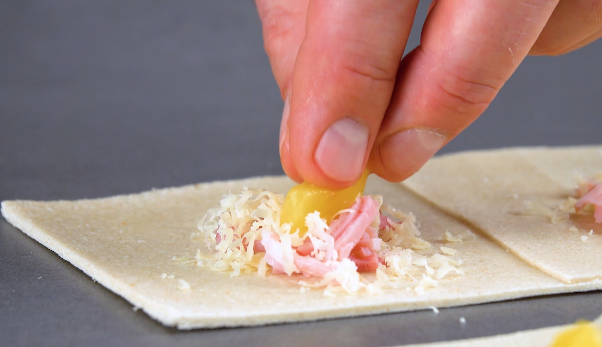 Toastbrot wird mit Schinken, Ananas und KÃ¤se belegt