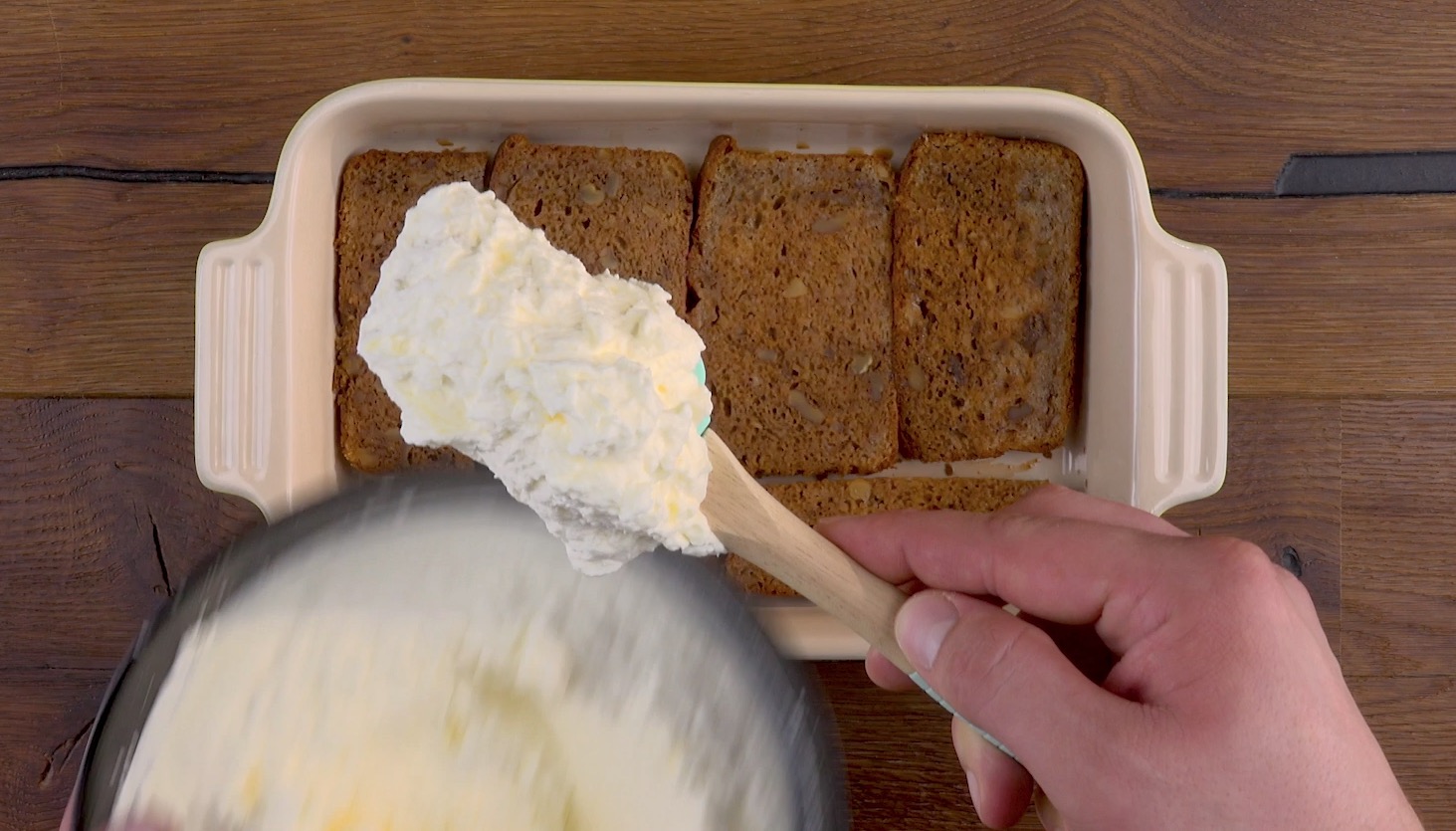 Sahne wird auf Bananenbrot verteilt