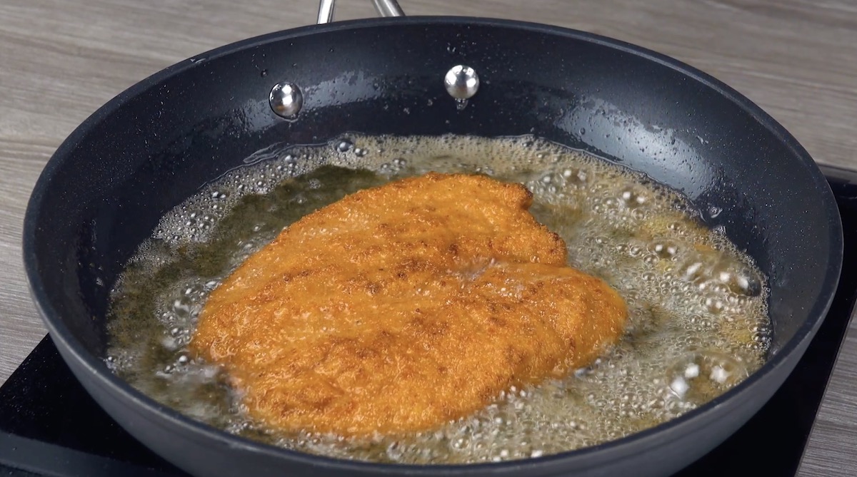 Panierte HÃ¤hnchenschnitzel werden angebraten