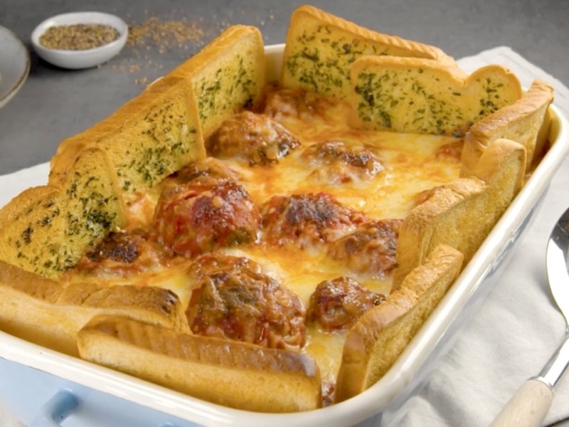 Köstlicher Hackbällchen-Auflauf mit Kräuterbutter-Toast-Zaun in der Auflaufform.