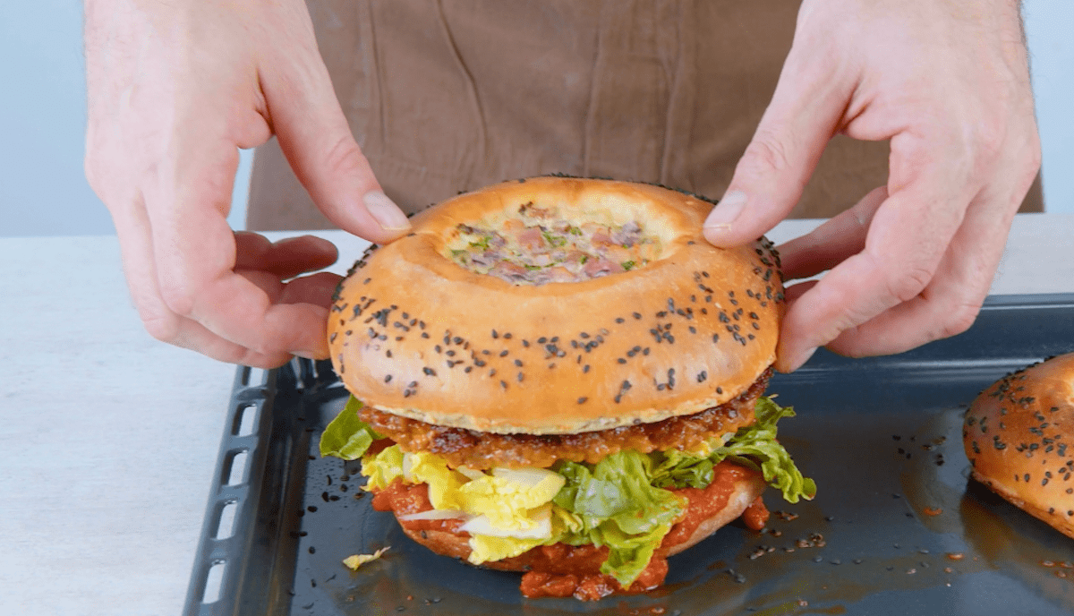 Burger-Bun mit Quiche-Masse wird oben auf den Quiche-Big-Mac gelegt