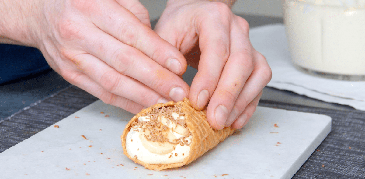 Cannoli mit Bananeneis werden geformt.