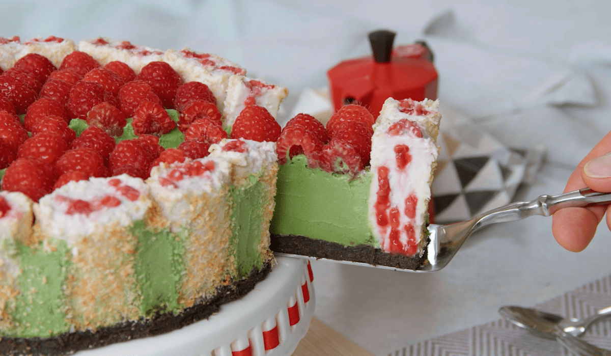 Ein StÃ¼ck von der Matcha Torte wird mit einem Tortenheber vom Rest getrennt