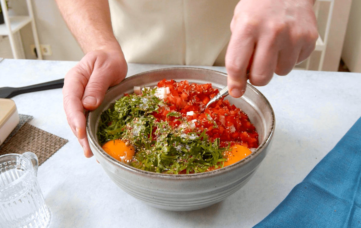 Hackfleisch wird in einer SchÃ¼ssel mit anderen Zutaten vermengt.