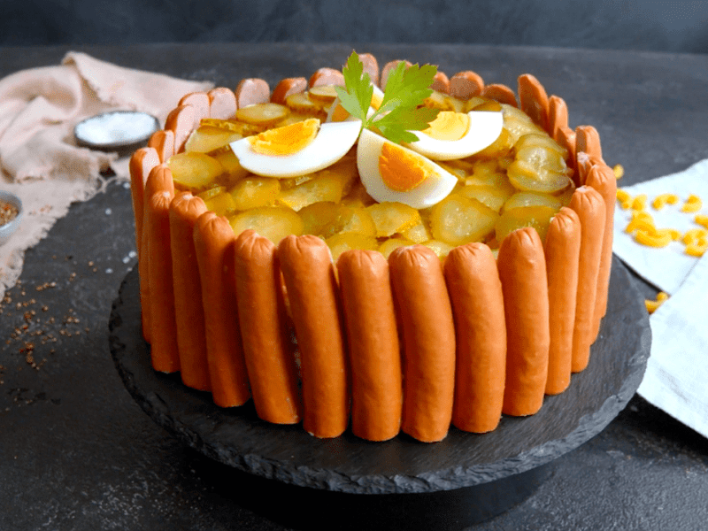 Nudelsalat als herzhafte Torte, angerichtet auf einem Teller.