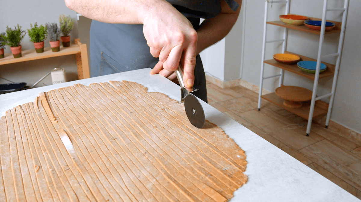 Brotnudeln werden zugeschnitten.