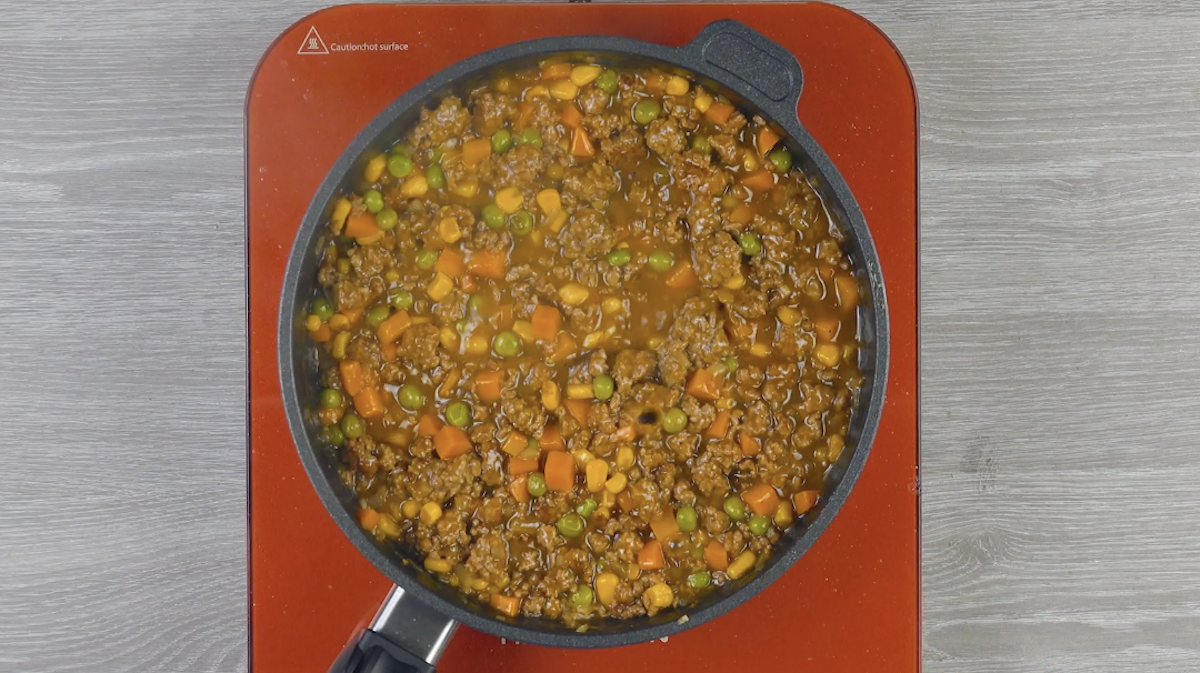 Hackfleisch mit MÃ¶hren und Erbsen in Pfanne