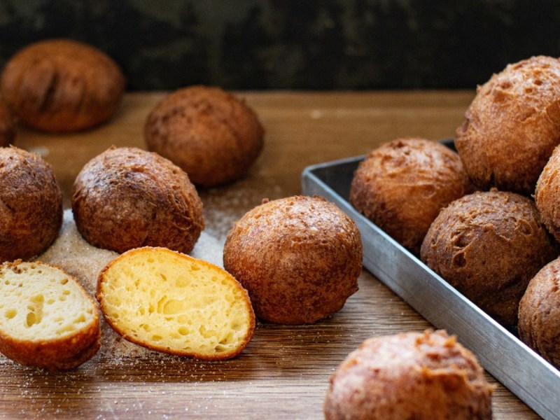 Süße Apfel-Quark-Bällchen, mit Puderzucker bestäubt.