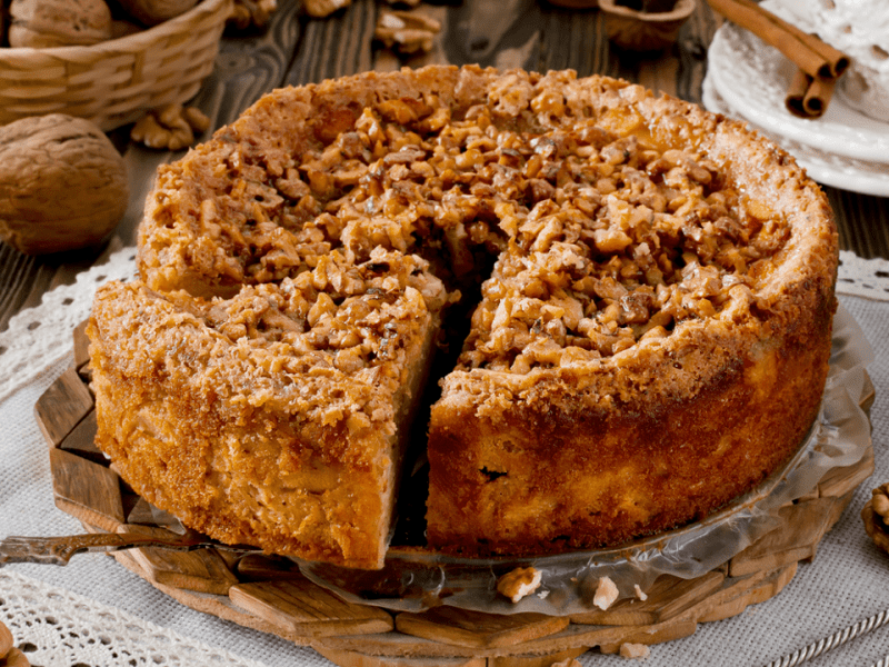 Apfel-Walnuss-Kuchen, serviert auf einem runden Blech.