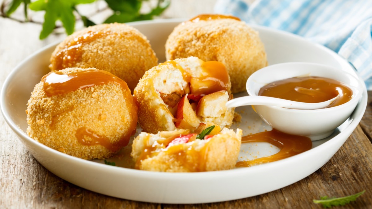 Apfelknödel mit Kartoffelteig auf einem Teller.