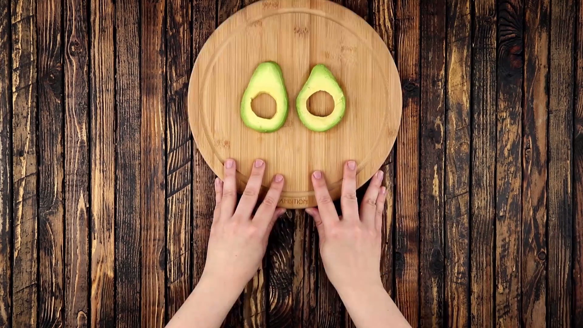 2 entkernte Avocadoscheiben auf Holzbrett