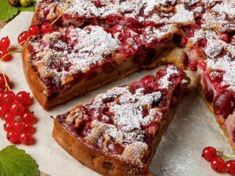 Kuchenplatte mit angeschnittenem Kuchen mit Beeren