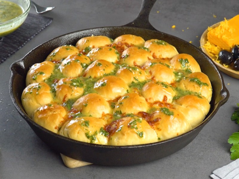 Hefebrötchen in Knoblauchsoße in einer Pfanne.