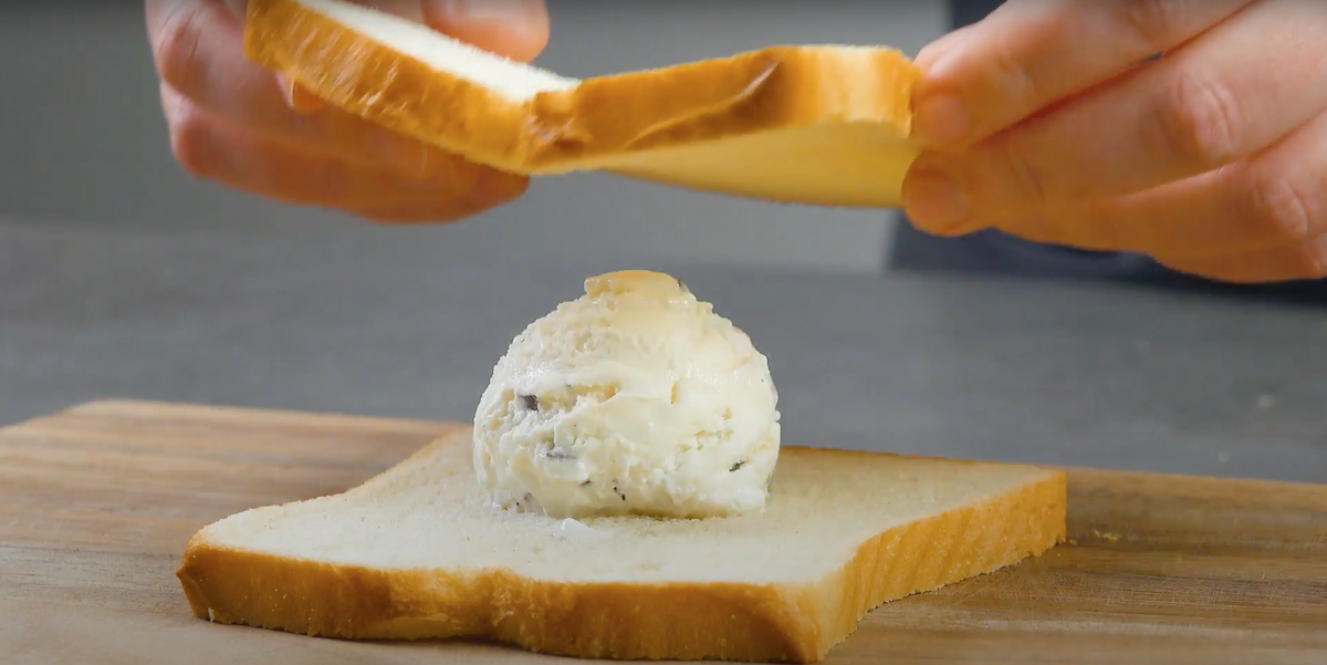 Eine Kugel Stracciatella-Eis wird zwischen zwei Toastscheiben gelegt