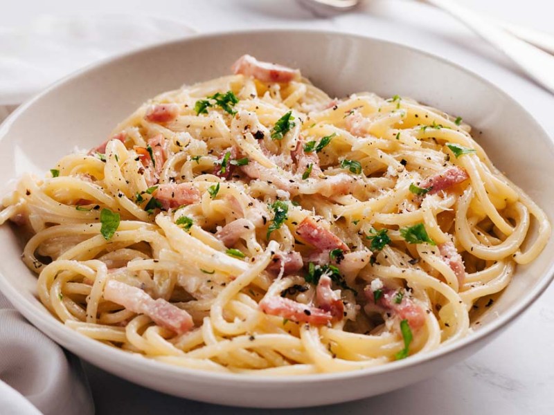 Eine weiße Schüssel mit französischer Spaghetti Carbonara.