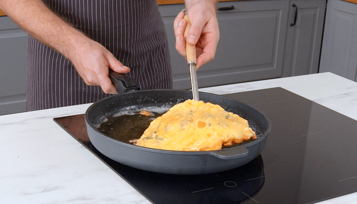 HÃ¼hnchenbrust in Parmesan-HÃ¼lle wird in einer Pfanne angebraten