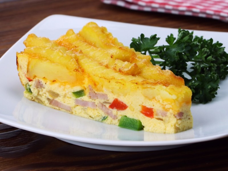 Weißer Teller mit einem stück Pommes-Torte mit Cheddar und Ei