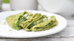 Spinatpfannkuchen mit Gorgonzola-Spinat-Füllung auf einem weißen Teller.