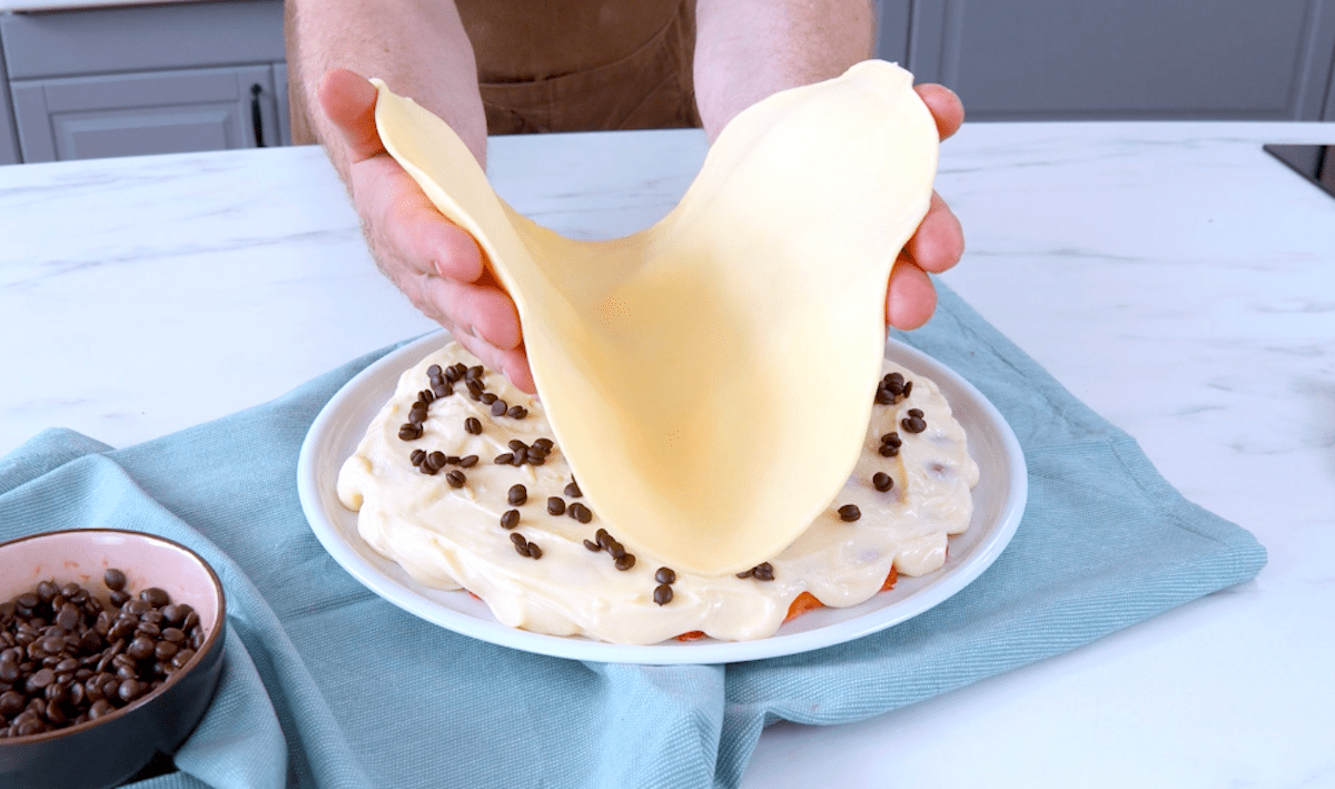 MÃ¼rbeteig wird auf Erdbeeren und Vanillepudding gelegt