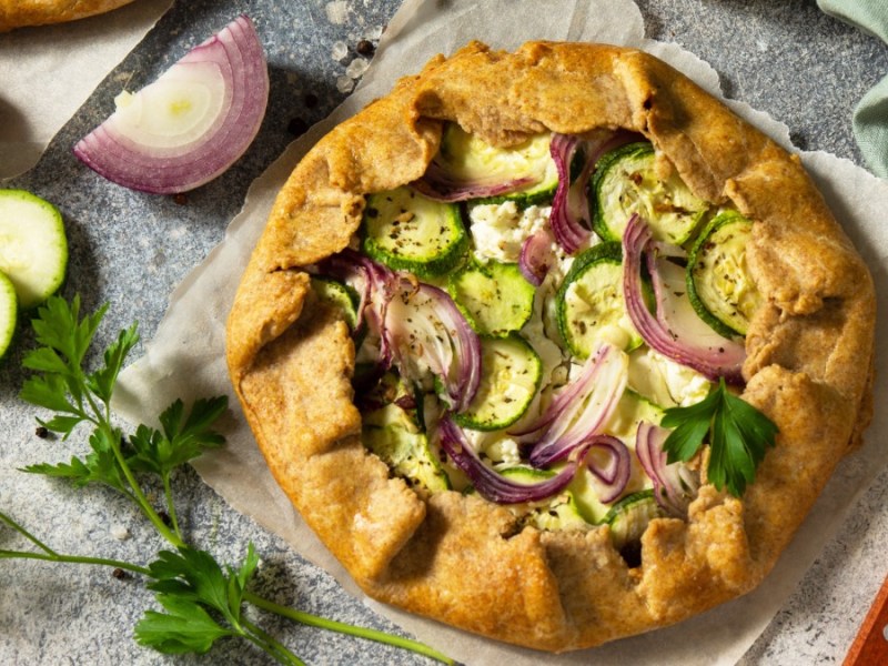 Zucchini-Galette mit Zwiebel und Feta auf einen Brett