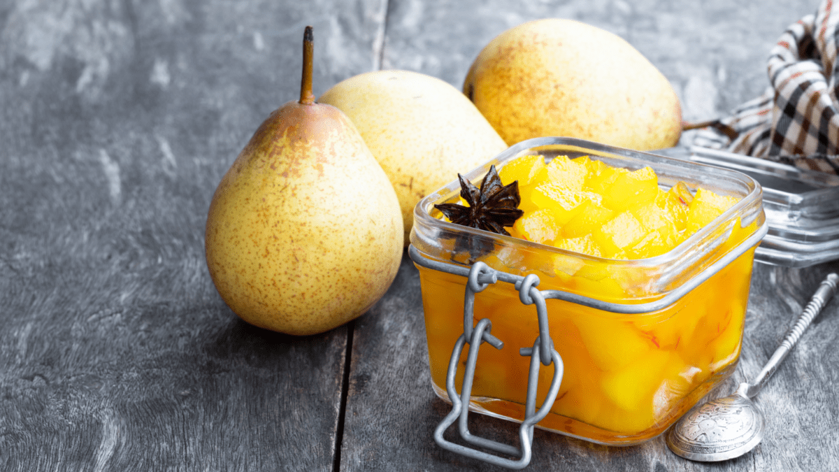 Birnen-Chutney im Glas mit frischen Birnen daneben