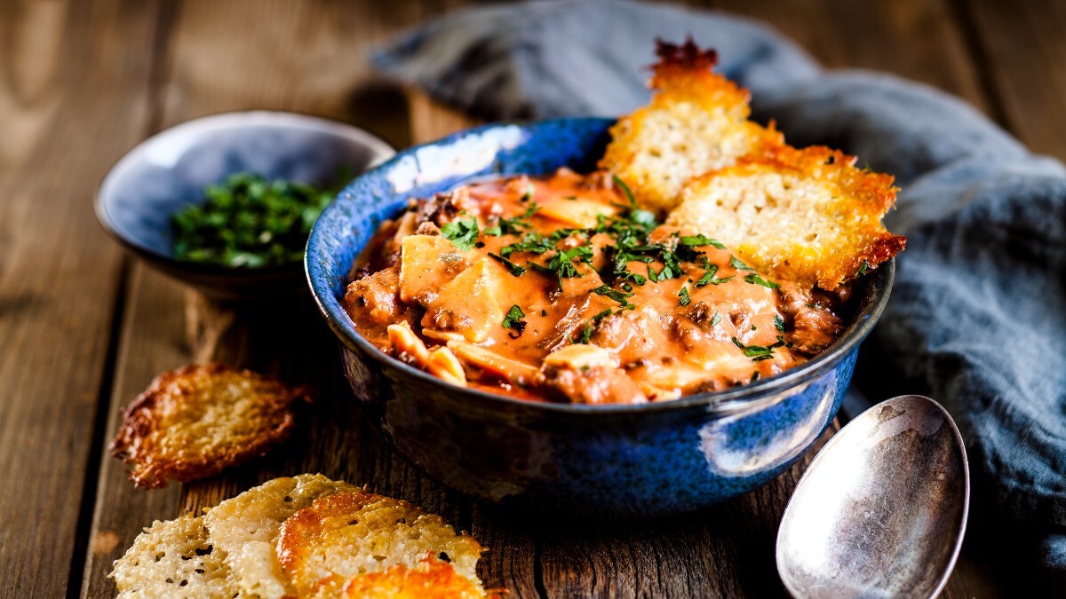 Eine SchÃ¼ssel Lasagne-Suppe mit Crackern aus Parmesan