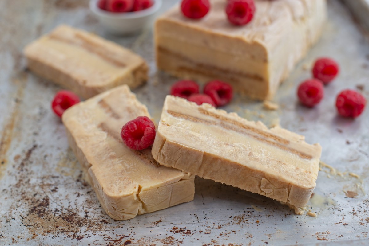 Marzipan-Spekulatius-Parfait auf einem grauen Untergrund mit Himbeeren garniert