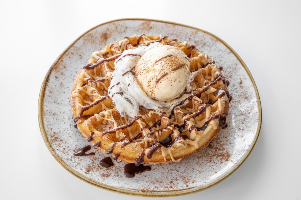 Churros-Waffel mit Eis und Schokoladenglasur auf einem hellen Teller