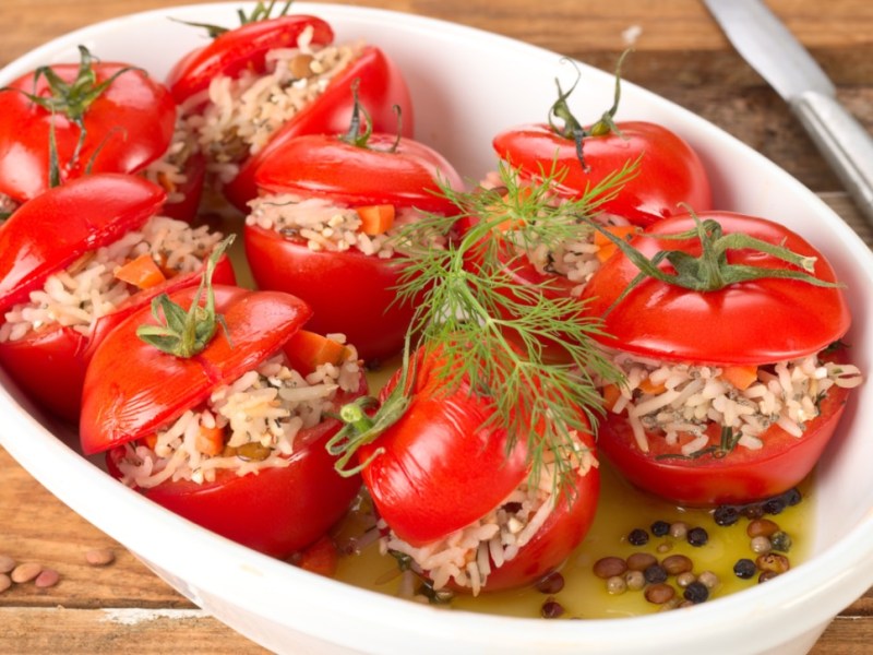 Mehrere gefüllte Tomaten in einer Auflaufform.