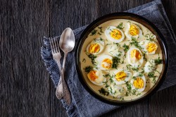 Schüssel mit halben gekochten Eier in Senfsoße.