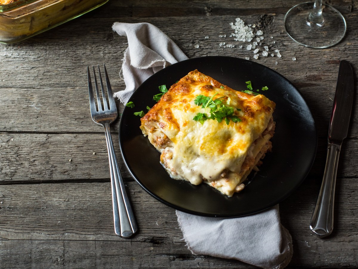 Teller mit Ei-Lasagne auf Holztisch