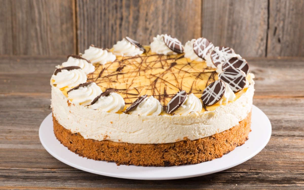 Eine Eierlikörtorte mit Schokoladenverzierung auf einer flachen Tortenplatte.