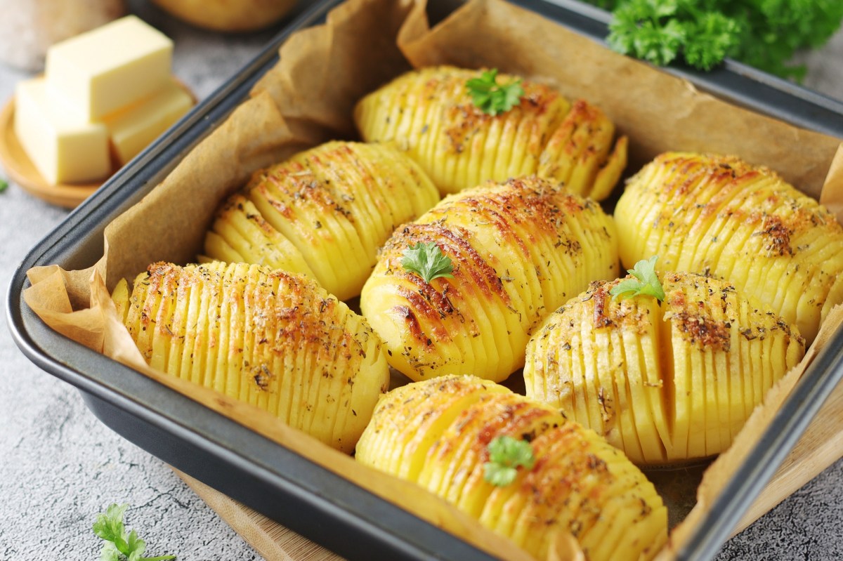 Fächerkartoffeln mit Knoblauch und Zitrone in einer quadratischen Auflaufform, Nahaufnahme.