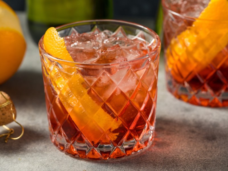 Zwei Gläser Negroni Sbagliato mit einer Orangenspalte.