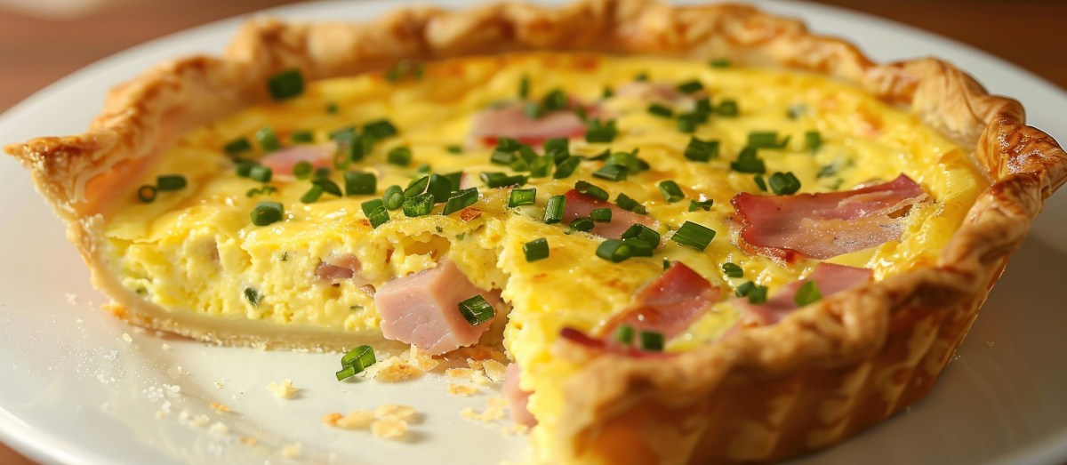 Angeschnittene Oster-Quiche mit Schinken und Ei.