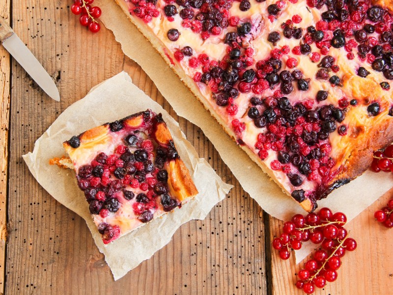 Buttermilchkuchen mit Beeren auf einem Holztisch