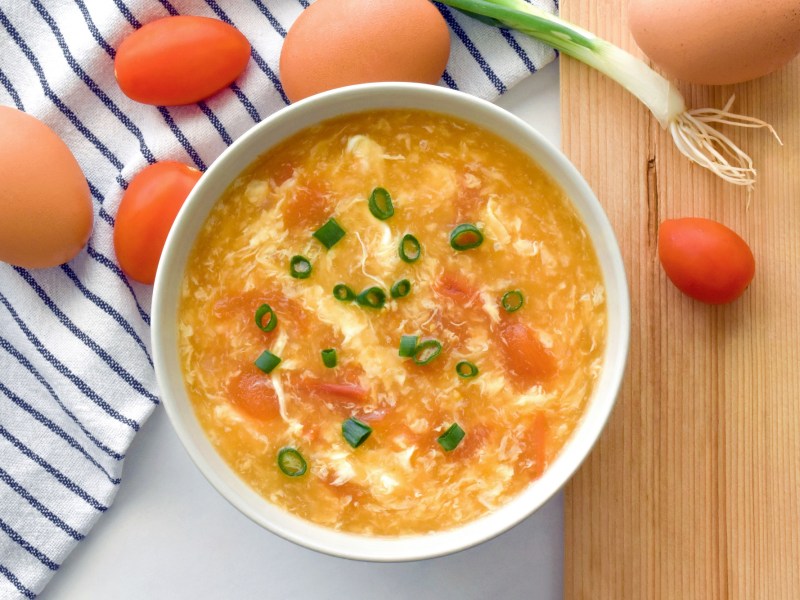 Eine Egg-Drop-Suppe mit Frühlingszwiebeln garniert.