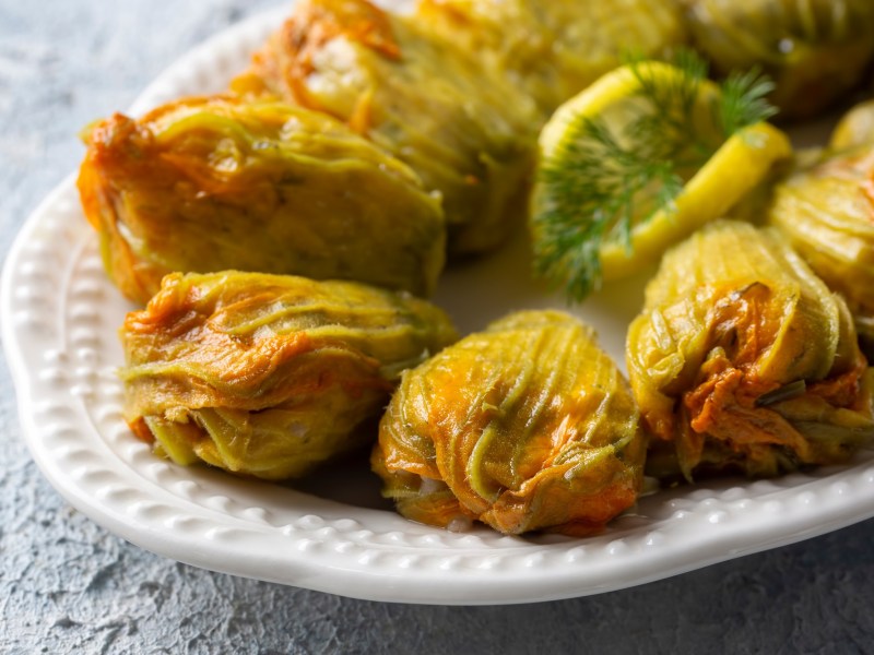 Gefüllte Zucchini-Blüten auf einem großen Teller.