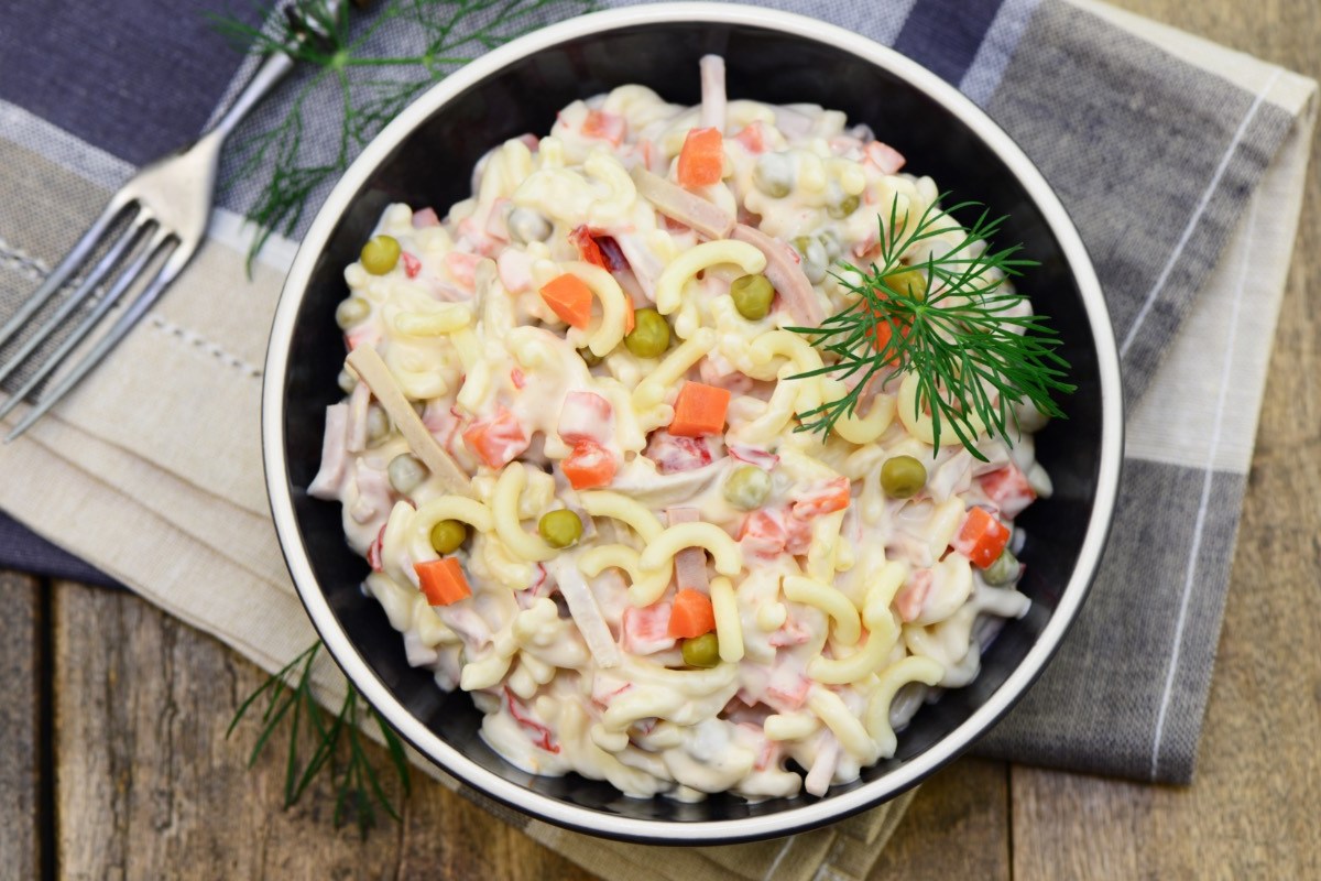 Eine Schüssel mit Nudelsalat mit Mayo in der Draufsicht.