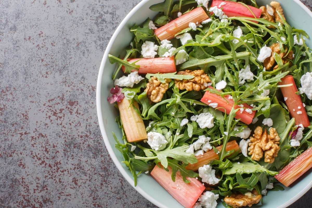 Schale mit Rhabarber-Rucola-Salat auf grauem Untergrund