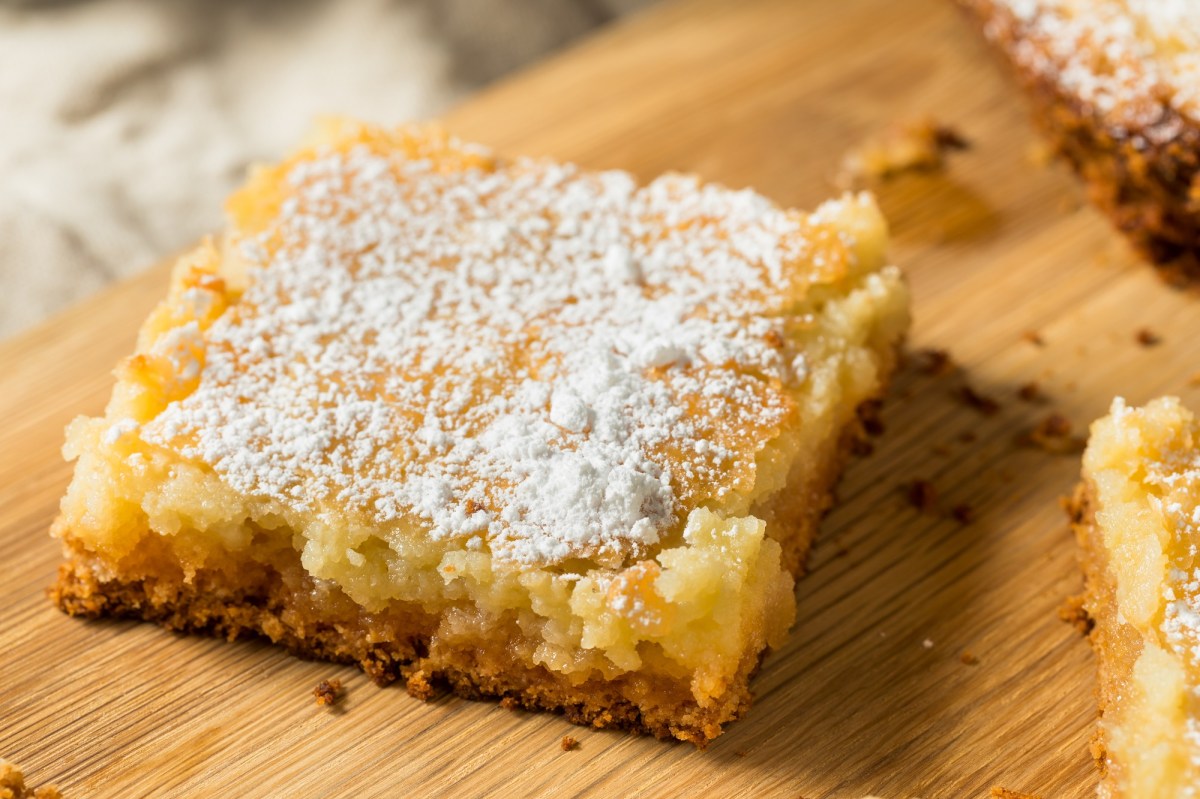 Ein Stück vom St. Louis Gooey Butter Cake auf einem Holzbrett.