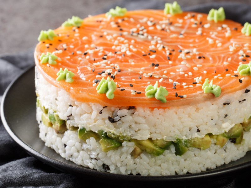 Die angerichtete Sushi-Torte auf einem Servierteller.