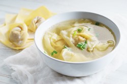 Wan-Tan-Suppe mit Frühlingszwiebeln garniert.