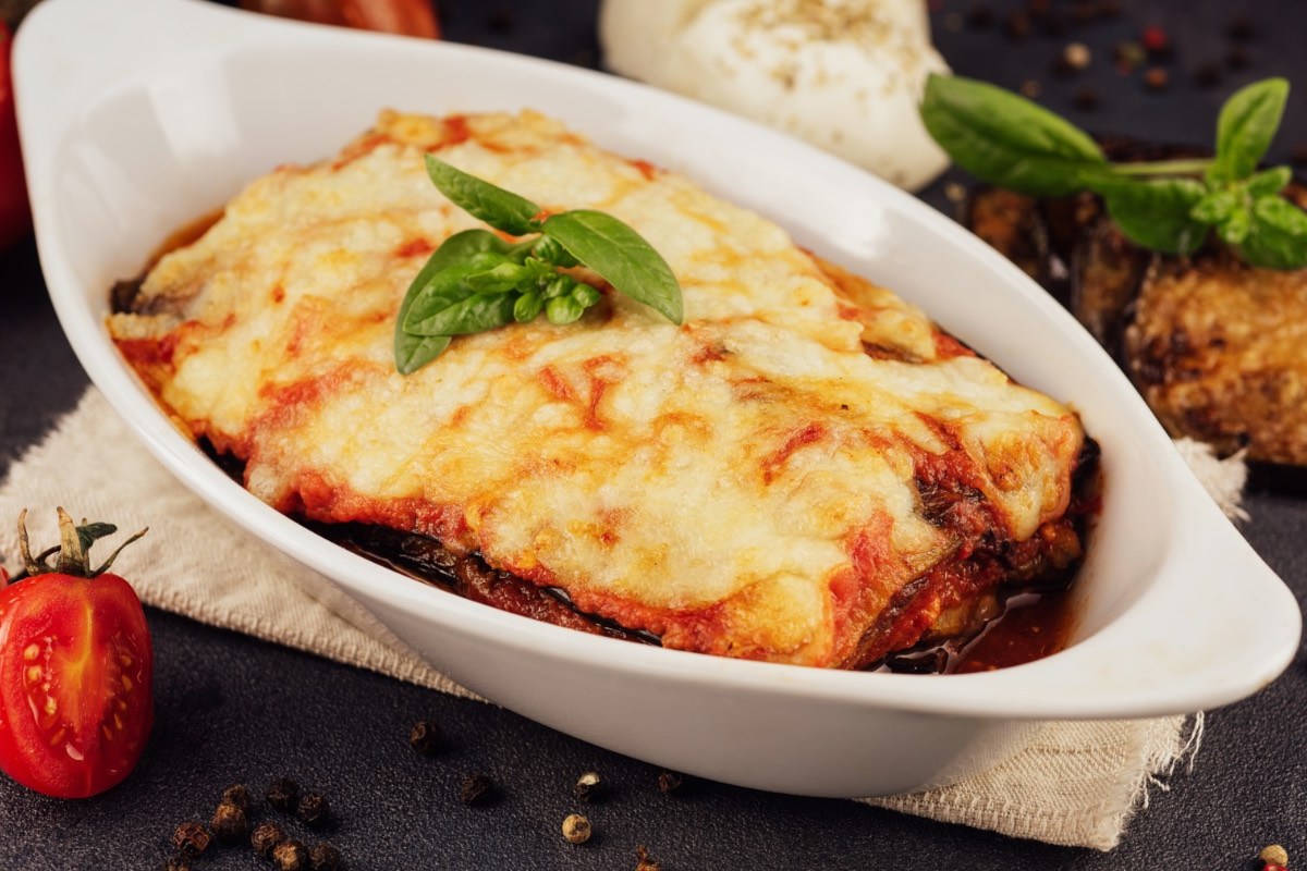 Eine Auberginen-Lasagne mit Käse in einer ovalen Auflaufform.